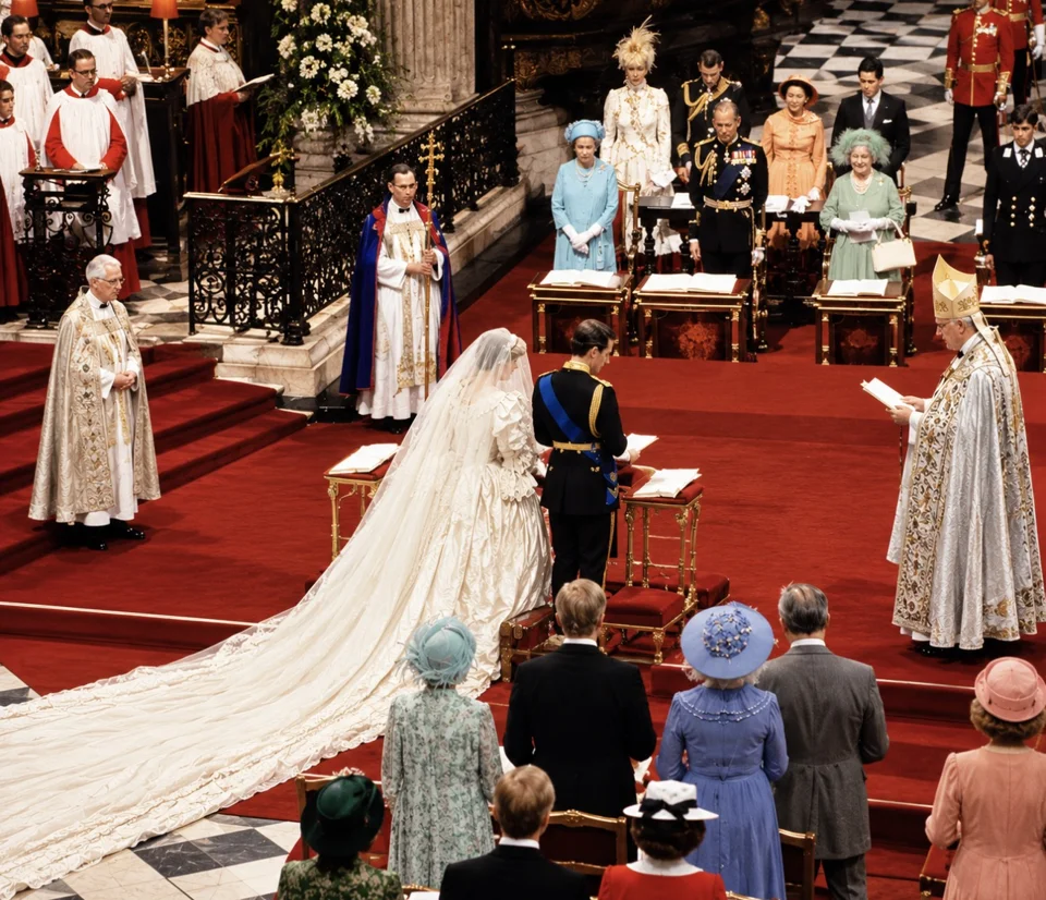 Charles and Diana standing at the wedding service with members of the Royal Family