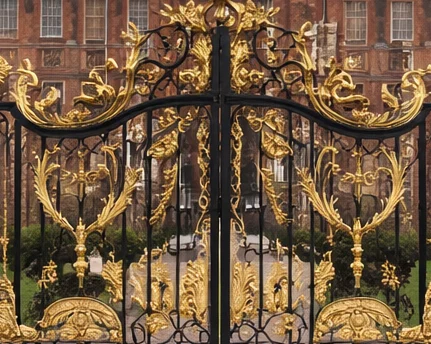 Gilded monogram detail on ornamental palace gates