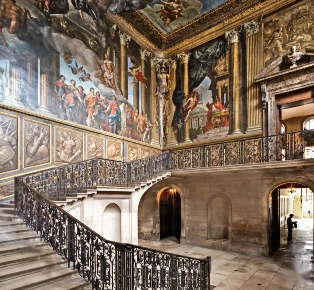 Iron balustrade of the King's Staircase beneath painted walls at Hampton Court Palace